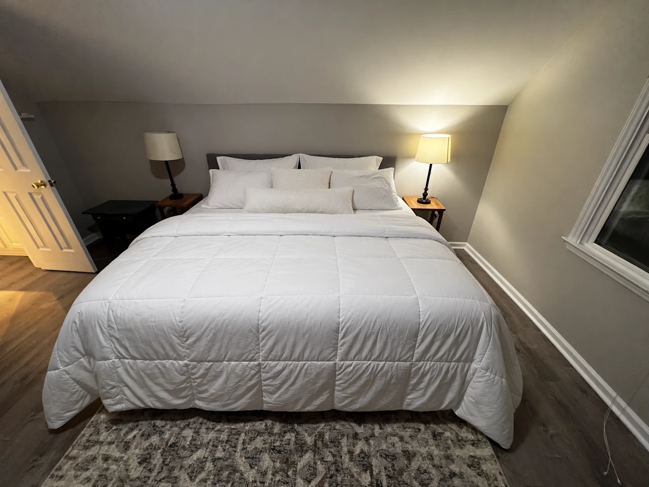 The same bedroom with smooth bedding and neatly arranged pillows, preserving the room and furniture